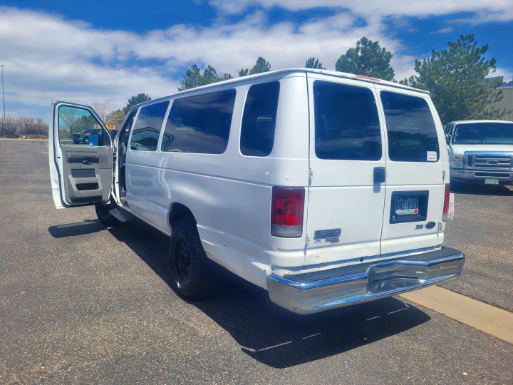 A white Ford E-350 passenger van with its door open. A versatile option for your next rv rental adventure.. Ford Ford E350 2009