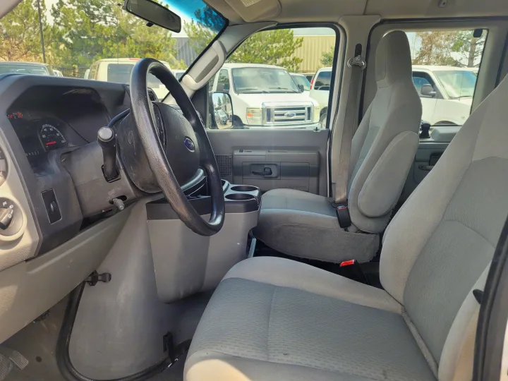 Interior of a Ford van, ideal for rv rental, showing driver's and passenger seats, steering wheel, and dashboard.. Ford Ford E350 2009