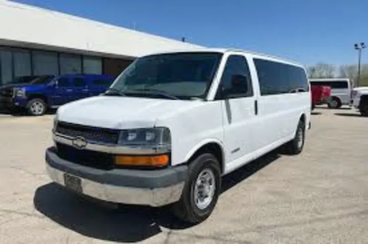 Front 3/4 view of a large white passenger van, a spacious rental option for groups. Consider it an RV rental alternative.. Chevrolet Express 1500 2009