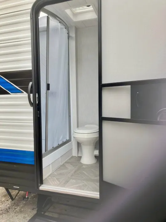 Explore this **RV rental**! Compact bathroom interior features a space-saving toilet and shower, perfect for your travel adventures.. Forest River Salem Cruise Lite 2023