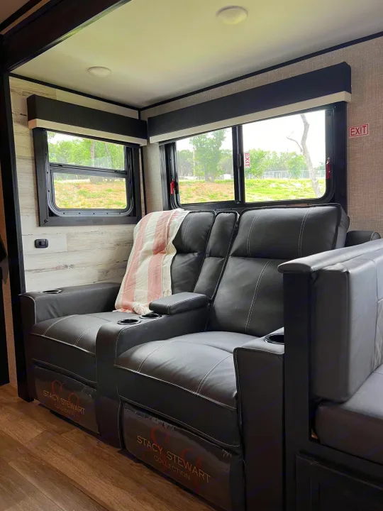 Inside a comfortable RV rental: black leather recliners with cup holders, blanket, and scenic window views.. Jayco Jay Feather 2022