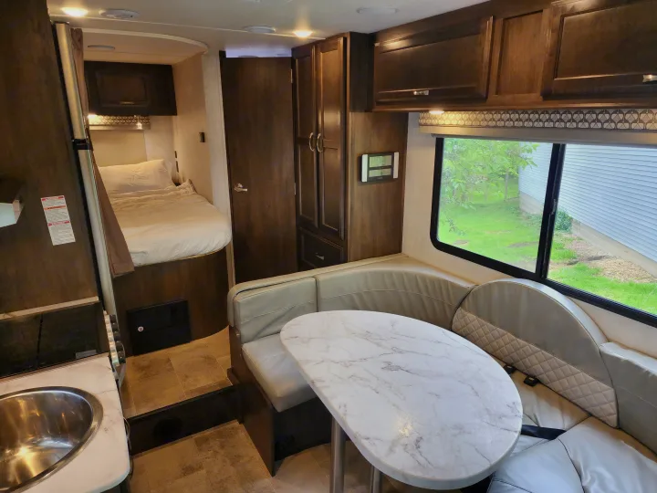 Explore this comfortable RV rental, featuring a spacious dinette, kitchen with sink, and cozy bedroom. Ideal for road trips.. Gulf Stream Conquest 2021