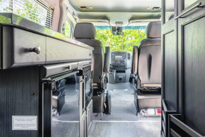 RV rental interior: View from rear to front, revealing kitchen unit, dashboard, seats, and a fire extinguisher.. Roadtrek Roadtrek Class B 2017