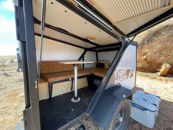 Compact Tiger Moth RV rental interior featuring a dinette converting to a bed, ideal for outdoor adventures.. TAXA Outdoors Tigermoth Camper 2021