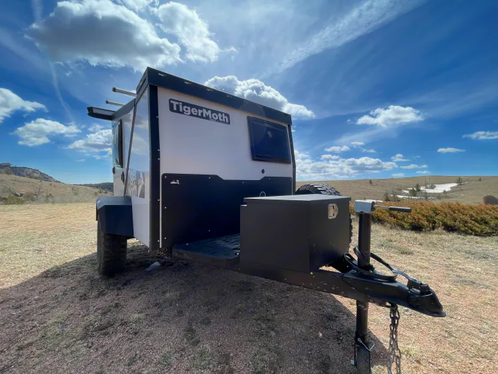 TigerMoth camper trailer, perfect for your next rv rental adventure, parked in a sunny, rugged landscape.. TAXA Outdoors Tigermoth Camper 2021