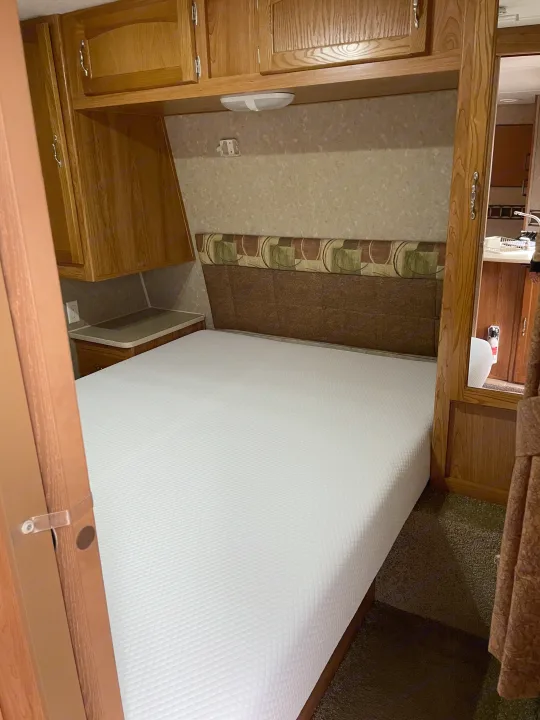 Cozy RV rental bedroom with new mattress, cabinets, and headboard.. Puma 30DBSS 2009