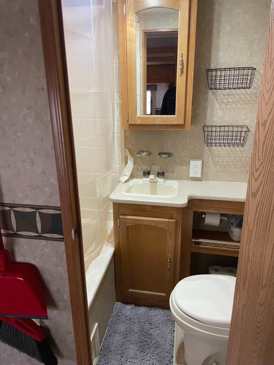This RV rental bathroom features a compact shower, sink vanity, toilet, and storage solutions, ideal for travel.. Puma 30DBSS 2009