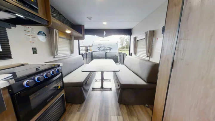 RV rental's functional interior: kitchen area, convertible dining/sleeping benches, and open rear ramp view.. Forest River Cherokee Grey Wolf 2018