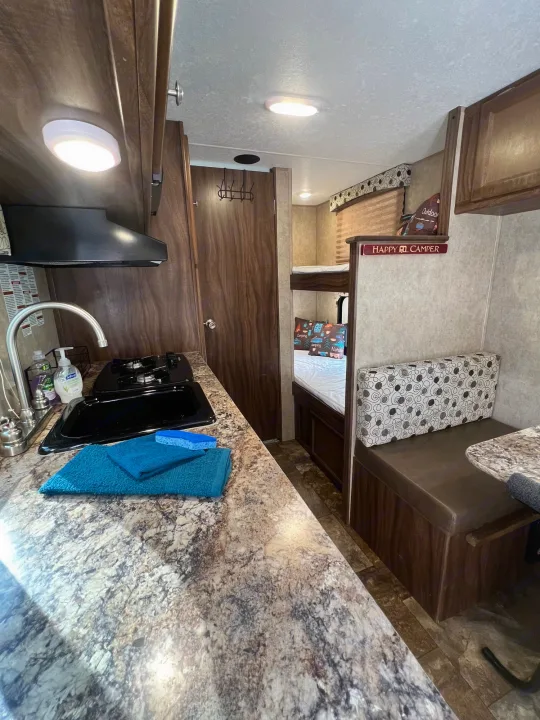Inside an RV rental: kitchen, bunk beds, and a cozy dinette. Ready for travel!. Coachmen Clipper 2016