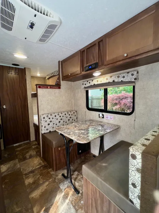 Cozy RV rental interior featuring a dinette, bunk beds, overhead AC, and cabinets for storage.. Coachmen Clipper 2016