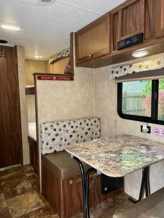 Bright RV rental interior with dinette, bunk beds, and overhead cabinets, perfect for family adventures.. Coachmen Clipper 2016