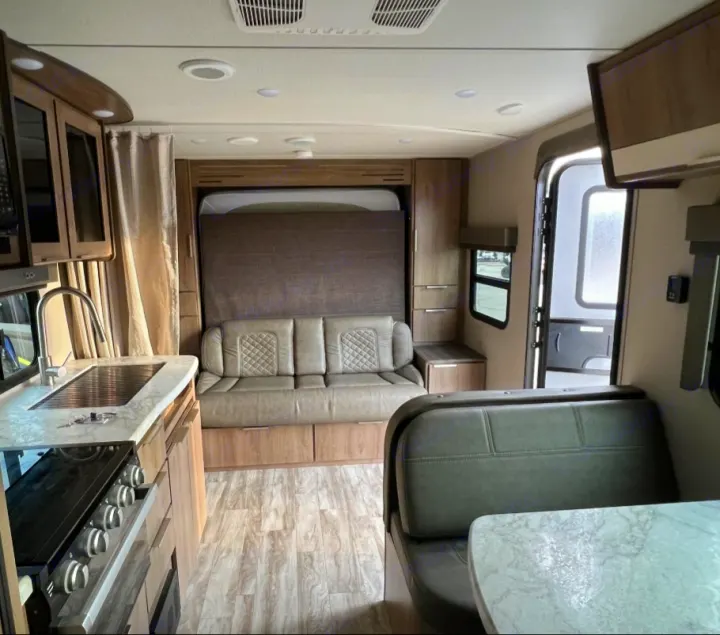 This rv rental's modern interior showcases a full kitchen, comfortable dinette, and space-saving murphy bed.. Grand Design Imagine XLS 2021