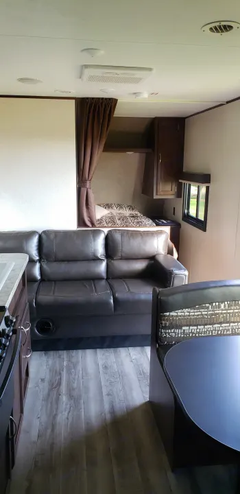 Spacious RV rental interior featuring a comfy sofa, dining area, kitchen, and bunk beds. Ideal for family trips.. Jayco Jay Flight SLX 2018