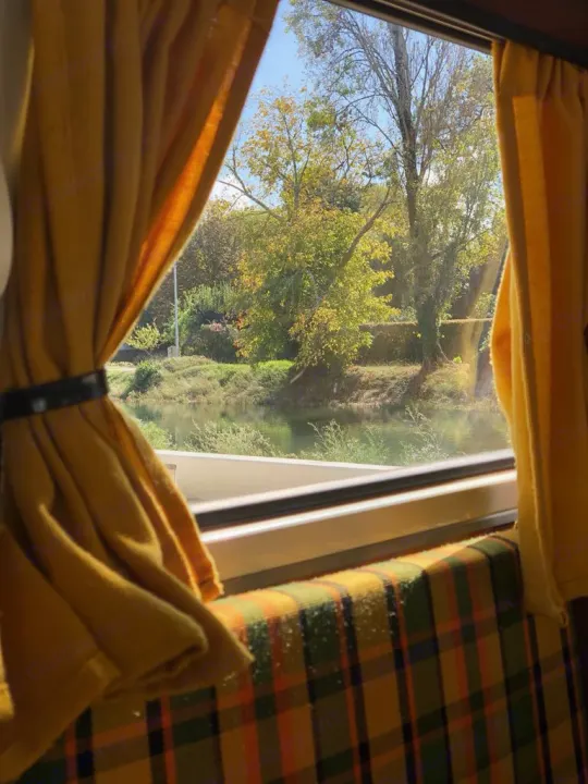 Enjoying a serene river view from a cozy RV rental. Autumn trees and plaid seats make for a perfect road trip!. Volkswagen T2 Westfalia 1979
