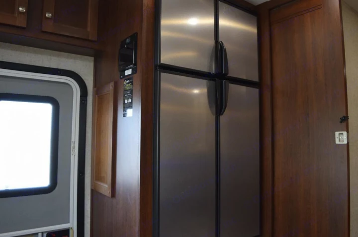 Spacious RV rental interior featuring a large stainless steel refrigerator, entry door, and control panel.. Forester Forester Motorhome 2020