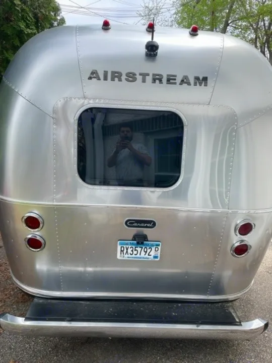 Rear view of a shiny, silver Airstream Caravel travel trailer with a MN plate, perfect for an RV rental getaway.. Airstream Caraval 2021