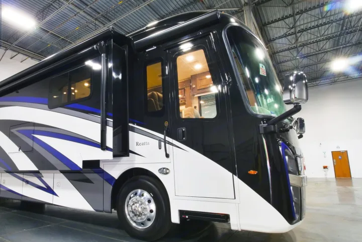 This sleek, new black, white, and blue RV motorhome, ideal for rv rental, displays its spacious interior and modern design.. Entegra Coach Reatta 2021