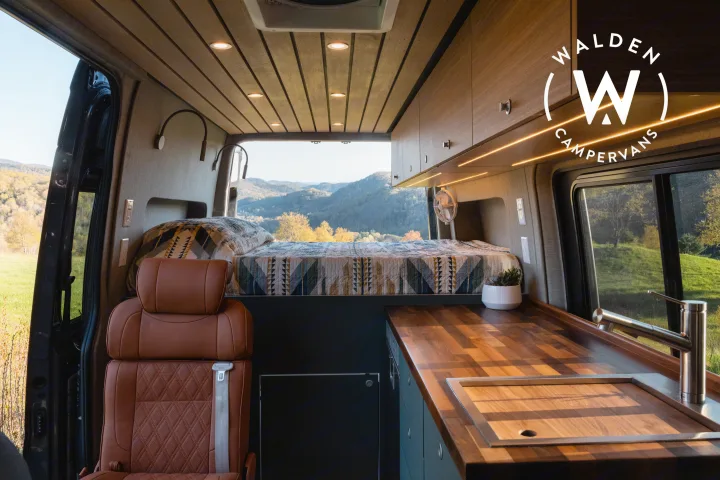 Walden Campervans: A modern RV rental interior with cozy bed, wood kitchen, and scenic mountain views.. Mercedes-Benz Sprinter 2023