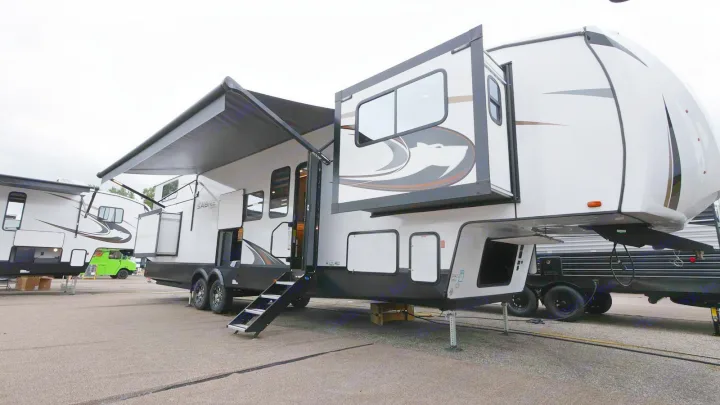 This spacious Sabre fifth-wheel RV, with awning extended, is ideal for your next rv rental and camping adventure.. Forest River Sabre 2021