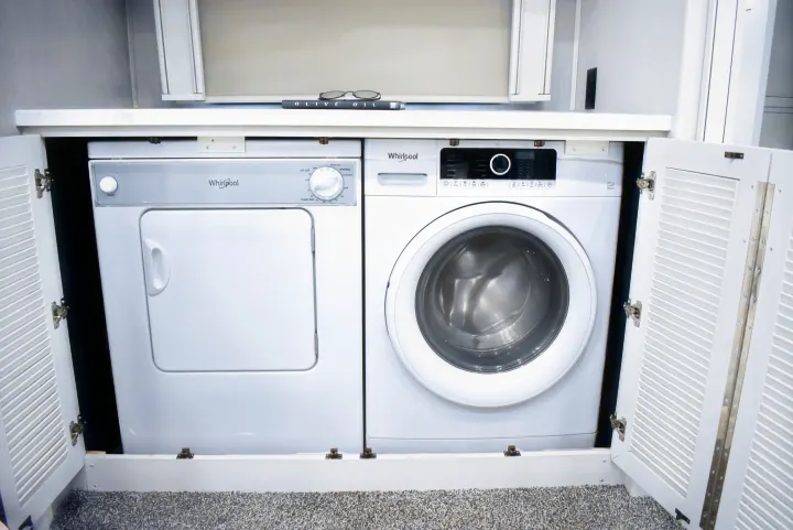 Compact Whirlpool washer and dryer for RV rental, providing convenient laundry in your motorhome.. Holiday Rambler Endeavor 2022