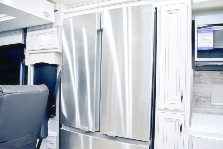 This rv rental offers a full kitchen with a large stainless steel Insignia refrigerator, white cabinets, & modern design.. Holiday Rambler Endeavor 2022