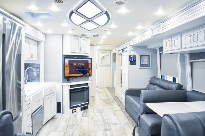 Spacious, modern luxury RV rental interior with kitchen, living area, and fireplace, ready for unforgettable experiences.. Holiday Rambler Endeavor 2022