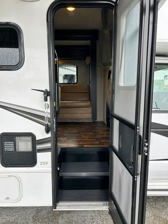 Open RV rental door showing entry steps, wood floor, and interior dinette. Ready for your next adventure!. Nexus Phantom 2020