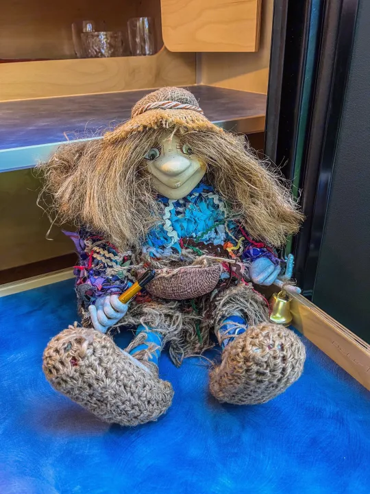A quirky troll doll with straw hair adds character inside this RV rental, resting on a blue shelf.. Aero Build Burnside 2023