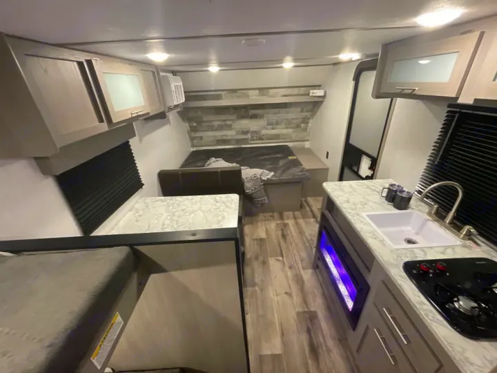 Modern RV rental interior with kitchen, bed, & cozy fireplace. Perfect for your next adventure!. Coleman Other 2022