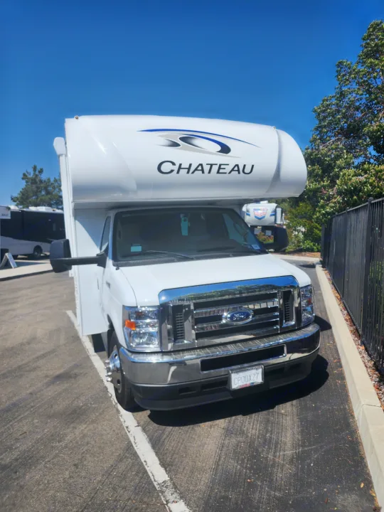 Front view of a white Ford Chateau RV rental parked on asphalt, offering mobile living and travel.. Thor Motor Coach Chateau 2023