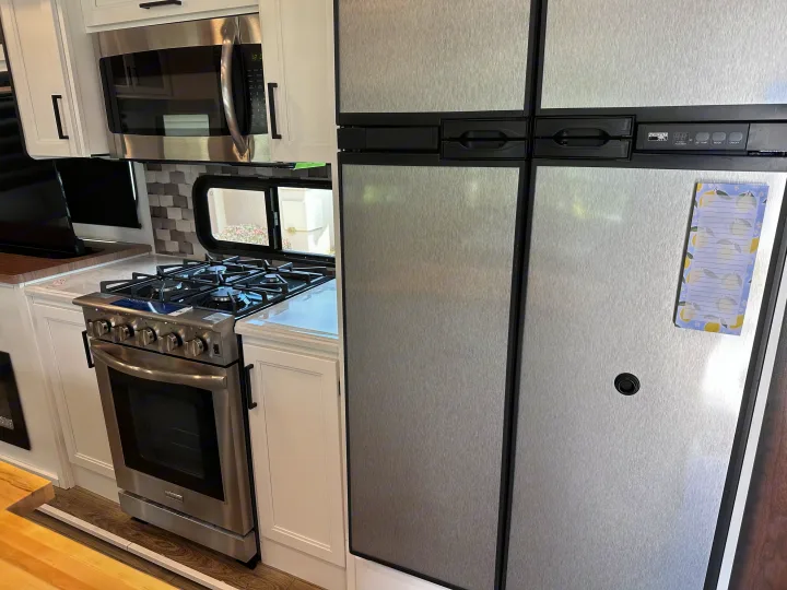 Well-equipped RV rental kitchen: stainless steel microwave, gas range/oven, and large Norcold refrigerator.. Crusader Crusader Fifth Wheel 2022