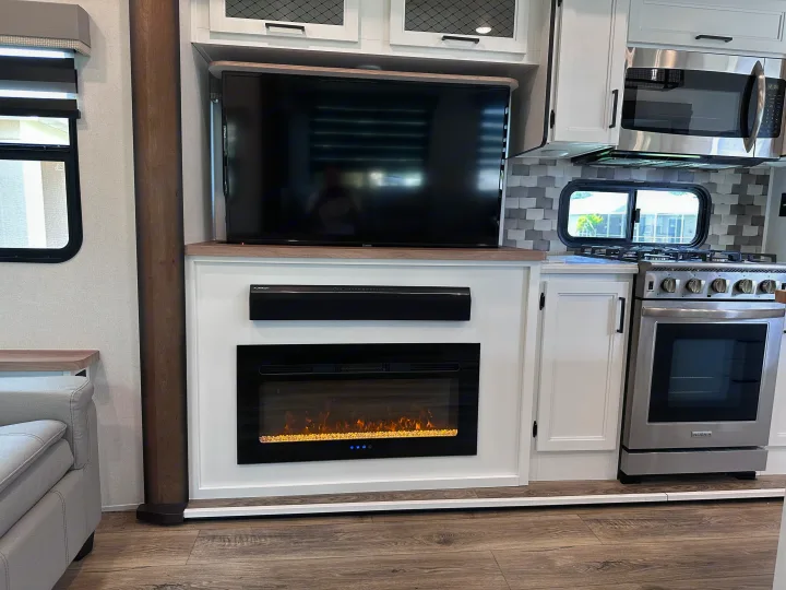 Tour this RV rental's modern kitchen with stove, microwave, and cozy living space featuring a TV and fireplace.. Crusader Crusader Fifth Wheel 2022