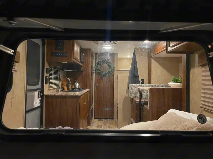 View of an RV rental interior with kitchen, dinette, and bedroom. Control panel reads AM 12:11, creating a cozy atmosphere.. Forest River Viking 2018