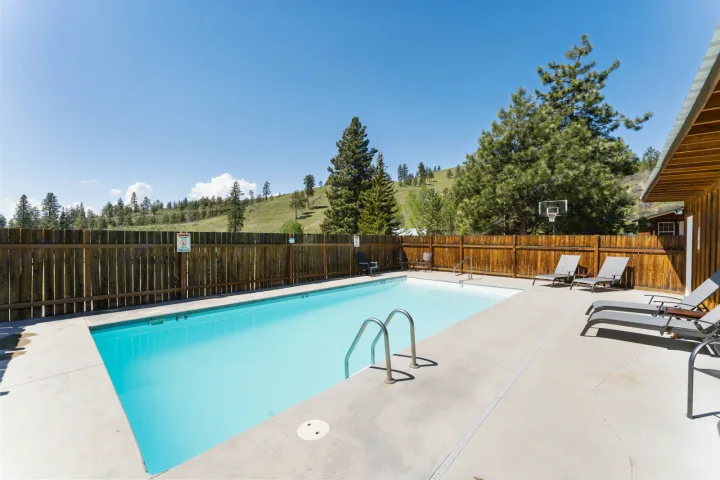 Relax by the pool at our scenic RV rental park, featuring a refreshing swimming pool, lounge chairs, and mountain views.. Airstream Flying Cloud 2023