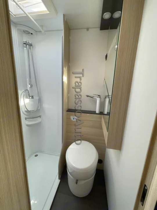 This RV rental's compact bathroom features a shower stall, toilet, and sink area, maximizing space efficiency for your travels.. SunLiving A 75 DP 2024