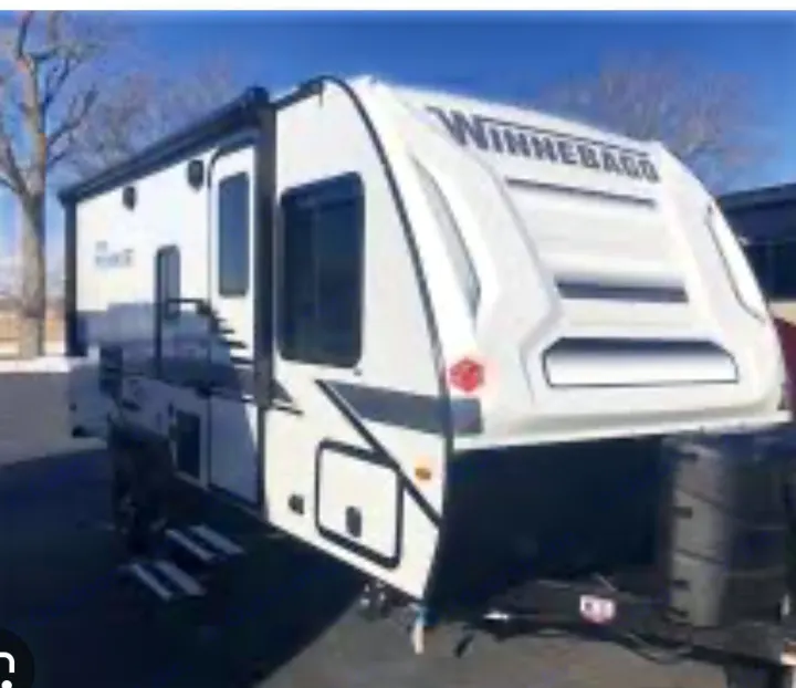 Modern white Winnebago travel trailer, ideal for rv rental. Features an extended awning and accessible steps.. Winnebago Micro Minnie 2100BH 2022