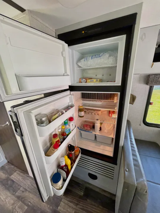 Fully stocked RV rental fridge/freezer with ice, food, and drinks, ready for travel adventures.. Keystone RV Bullet Crossfire 2019