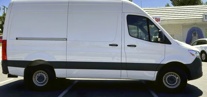 A clean white cargo van, often chosen for RV rental conversions, parked on asphalt.. Mercedes-Benz Sprinter 2021