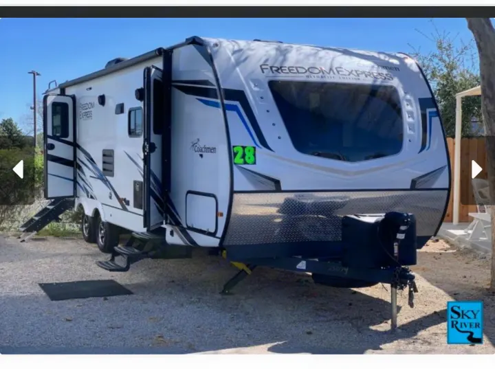 White Coachmen Freedom Express travel trailer (RV rental #28) parked on gravel, with steps extended.. Coachmen freedom express 287bhds 2022