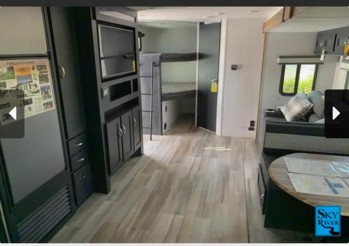 Spacious RV rental interior featuring bunk beds, a living area, and entertainment center, perfect for family adventures.. Coachmen freedom express 287bhds 2022