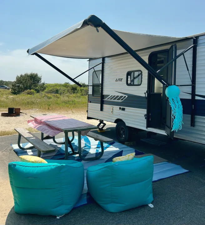 Enjoy your rv rental adventure! This comfortable campsite setup features an RV with an awning, picnic table, and outdoor seating.. Crossroads RV Zinger Lite 2022
