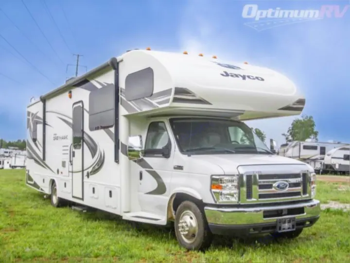 A white Jayco Greyhawk Class C motorhome, ready for RV rental, parked on green grass under a blue sky.. Jayco Greyhawk 2021
