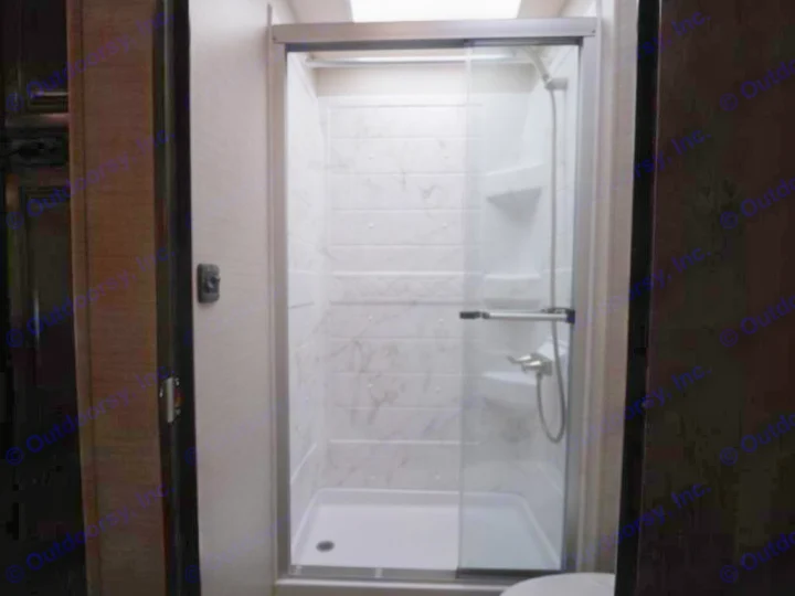 Inside an RV rental: a shower with a glass door, white marble-look walls, and a handheld shower head.. Jayco Greyhawk 2021