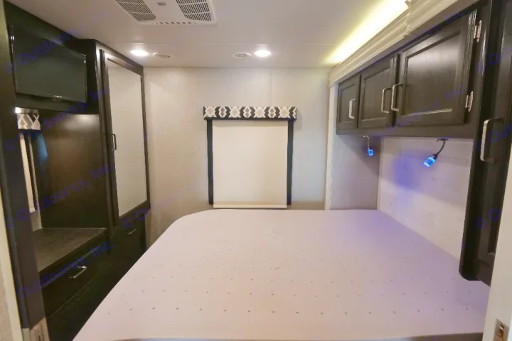 RV rental bedroom: comfortable bed, TV, mirrored wardrobe, window, overhead storage, and blue lights.. Jayco Greyhawk 2021