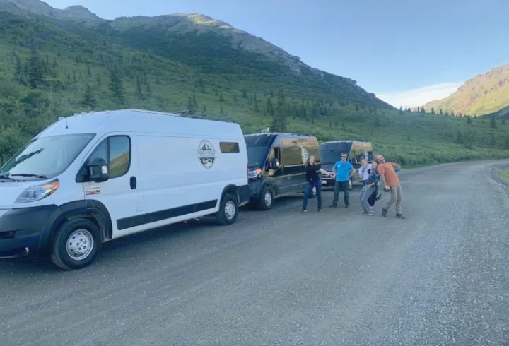 Ready for an RV rental road trip! Friends gather with camper vans on a dirt road through scenic mountains.. Dodge Promaster 2500 (Class B) 2022