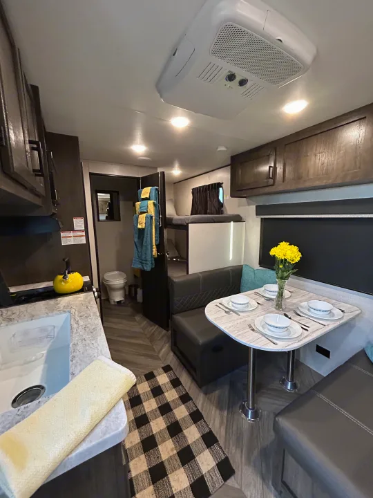 Cozy RV rental interior featuring a functional kitchen, dining area, and bunk beds, perfect for travel comfort.. Olympia Sport 2022