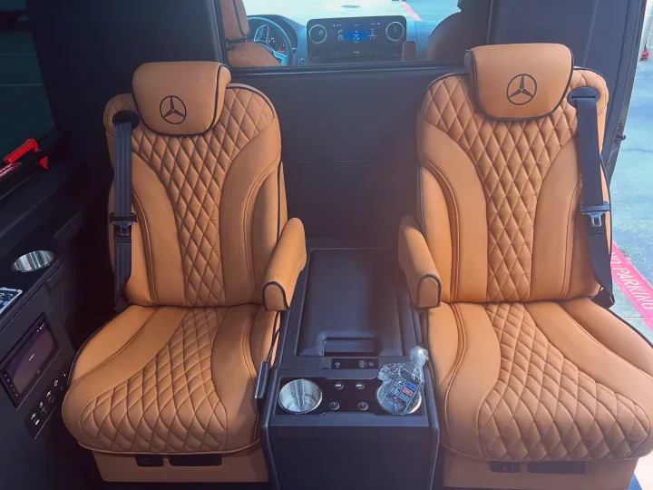Plush tan leather Mercedes-Benz seating within a spacious RV rental, featuring diamond quilting and central console amenities.. Mercedes Benz Sprinter 2022