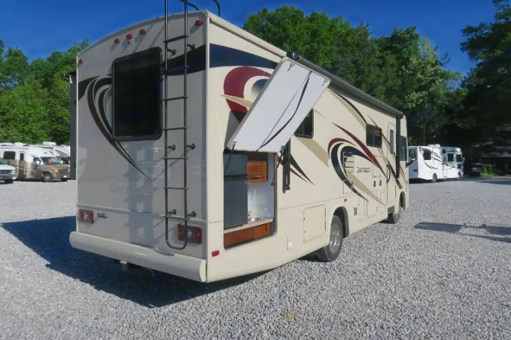 Discover this tan RV rental. Rear view showing a ladder and side storage with an outdoor kitchen, perfect for camping.. Forest River Georgetown 2018