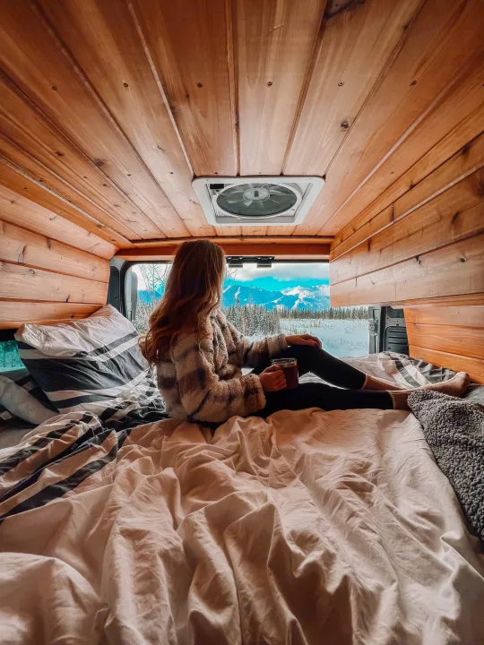 Experience cozy winter van life in this rv rental, enjoying snowy mountain vistas from bed.. Dodge Ram 2500 (Class B) 2021