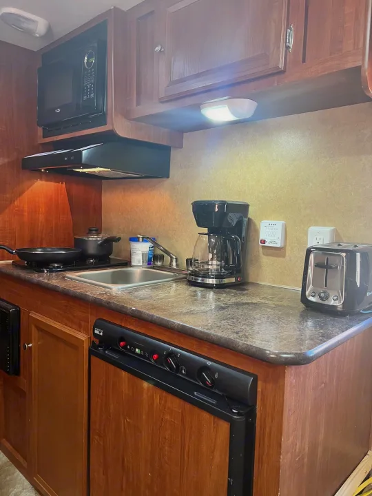 This RV rental kitchen features a microwave, stovetop, sink, coffee maker, toaster, and refrigerator, ready for your adventures.. Jayco Jay Flight Swift 154 BH Slx 2013